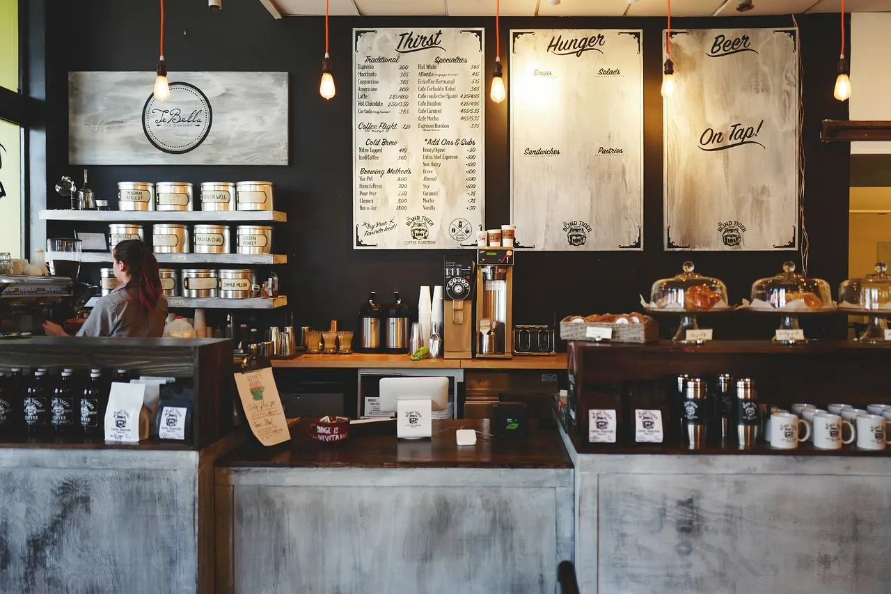 Warm coffeehouse interior with pendant lights, a wooden bar, and an espresso machine